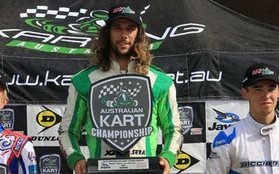 David Sera on the top step of an Australian Kart Championship podium holding the winner board